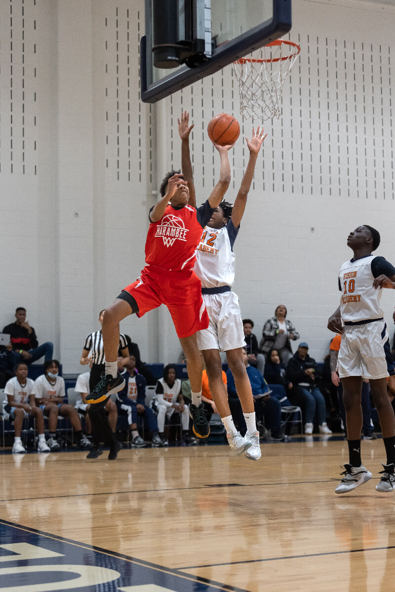 player going for dunk while another player tries to block