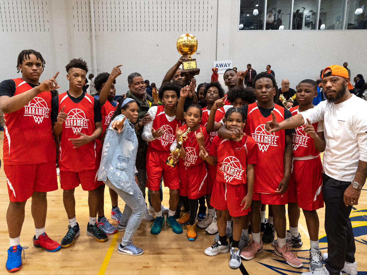 basketball team and coach holding trophy